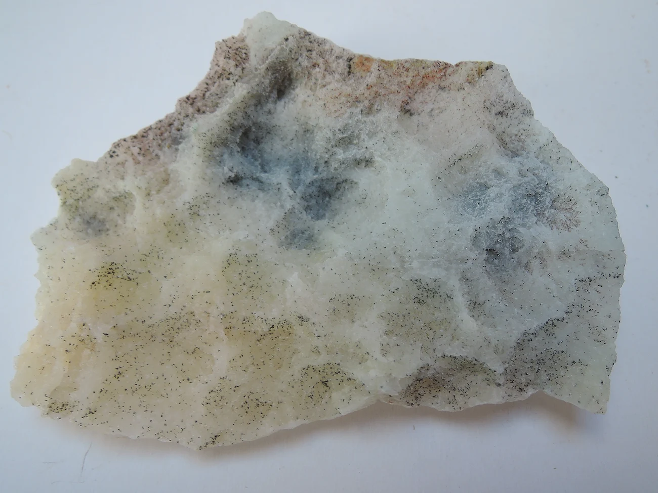 Fragmento de quartzo leitoso (industrial), textura maciça branca com inclusões minerais — imagem de referência.